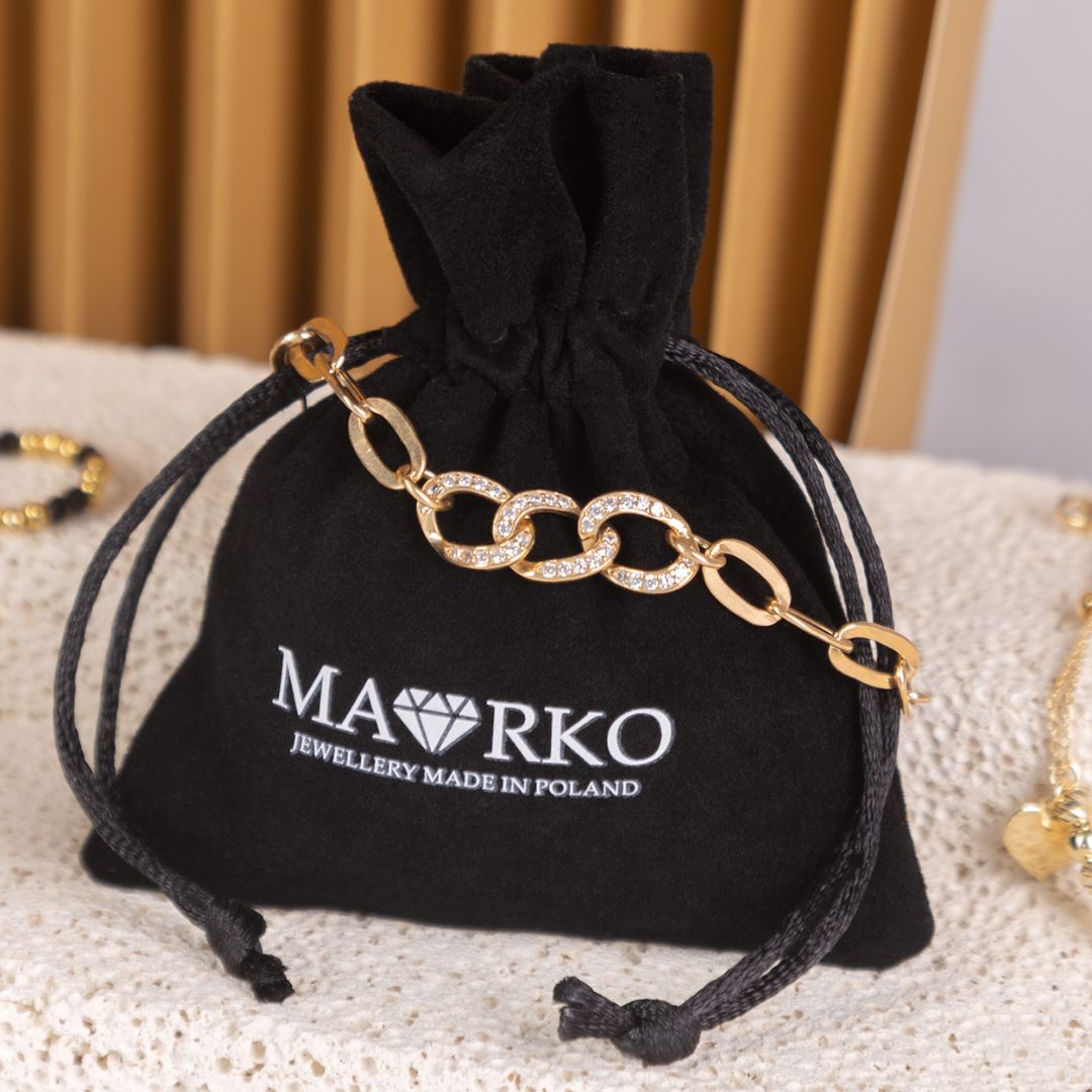 Zwarte fluwelen pochette voor sieraden met MAORKO-logo en gouden ketting.